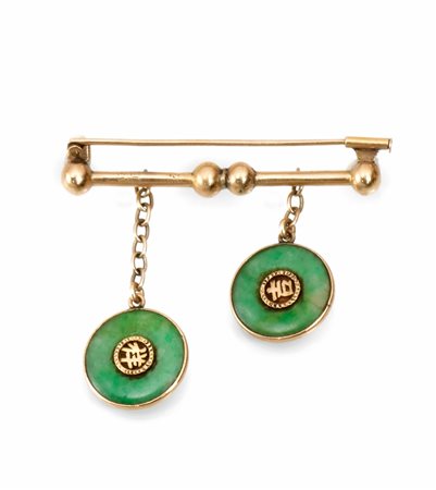 Spilla in oro giallo e giadarealizzata come una barretta a cui sono sospesi...