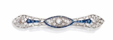 Spilla in oro bianco, diamanti e zaffiridisegnata come una barretta sagomata...