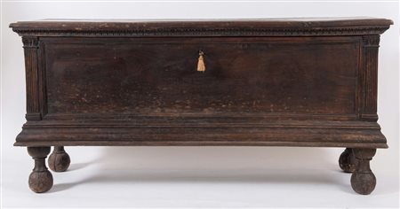 Grande cassapanca in legno di noce. Reca lesene a guisa di colonne agli angoli. Cornicioni fortement