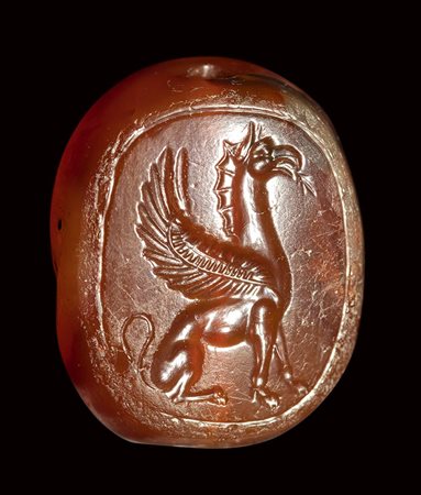 An early classical greek carnelian scaraboid intaglio. A seated griffin. <br><br>5th century B.C.