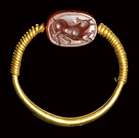 An etruscan carnelian scarab intaglio set in a  gold swivel ring. Bull. <br><br>3rd century B.C.
