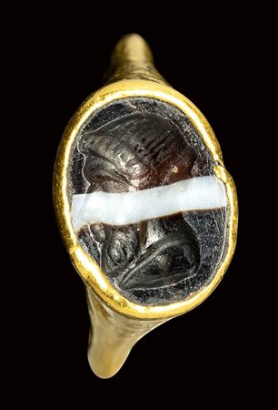 A late hellenistic gold ring set with a banded agate intaglio.  Bust of Herm.<br><br>2nd century B.C.