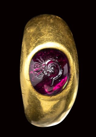 A roman gold ring set with a garnet cabochon intaglio. Butterfly metamorphosis.<br><br>1st century B.C.