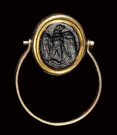 A roman dark glass paste intaglio set in a gold swivel ring. Eagle.<br><br>1st - 3rd century A.D.