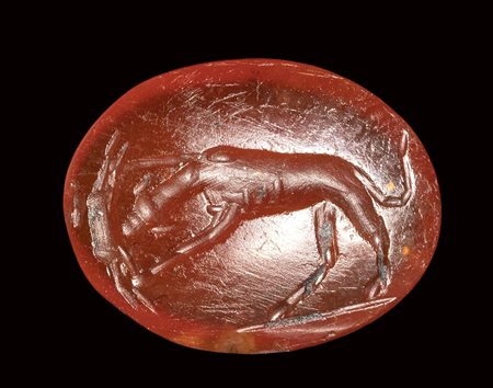 A roman carnelian intaglio. Dog with prey.<br><br>1st - 2nd century A.D.