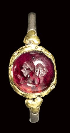 A late roman bimetallic ring with garnet cabochon intaglio. Eros. <br><br>3rd century A.D.