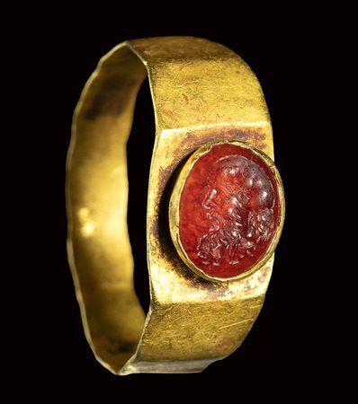 A roman carnelian intaglio set in a gold ring. Head of a Silenus.<br><br>2nd century A.D.