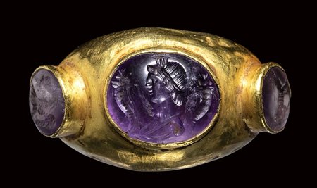 A large roman gold ring set with three amethyst intaglios. Eagle, Male portrait with cornucopia  and a sow. 3rd century A.D.