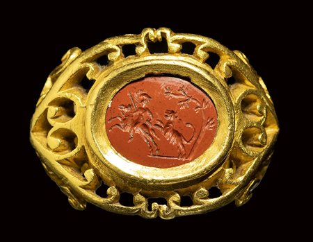 An important roman openwork gold ring set with a red jasper intaglio. Hunting scene. 2nd - 3rd century A.D.