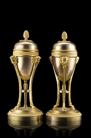 Coppia di candelieri in bronzo a forma di vasi con prese a pigna. Montanti term