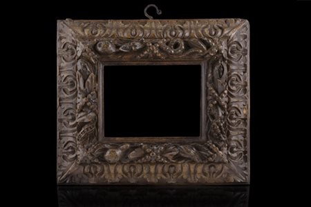 Cornice in legno intagliato a foglie, frutta e serpente avviluppato. Secolo XVI