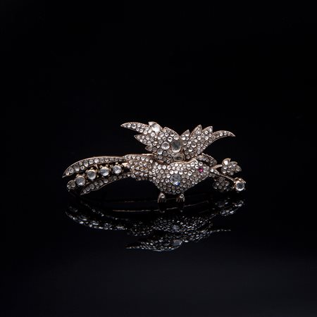 Spilla in forma di uccello con lunga coda e con un ramo nel becco, in diamanti e rubini