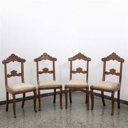 Quattro sedie in noce con schienale intagliato