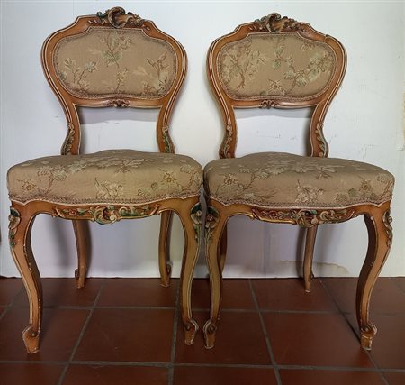 Due sedie in legno intagliato e laccato con rivestimento in tessuto operato