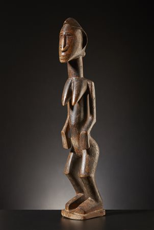  Dogon - Mali  - Figura femminile di antenata.
Legno duro a patina chiara e lucida, con tracce di pigmento.
Difetti e segni d'uso.