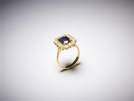  . - Anello in oro giallo 750/1000 con contorno di diamanti tondi taglio a brillante di 1,00 ct circa H/I vs  e zaffiro blu  centrale taglio a cuscino di 3,00 ct circa. .