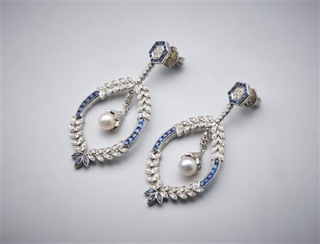  . - Un paio di orecchini "Liberty" pendenti in oro bianco 750/1000 con zaffiri blu carrè, diamanti bianchi  taglio huit huit e perle sferiche. .