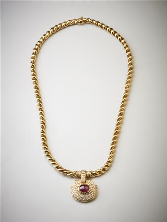  . - Collana in oro giallo 750/1000 maglia intrecciata con ciondolo con pavè di diamanti bianchi taglio brillante carati 2,80  ca. e rubino ovale cabochon di  3,00 carati circa.