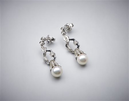  . - Orecchini pendenti in oro bianco 750/1000 con coppia di perle sferiche bianche coltivate di mm 8,50 e piccoli diamanti bianchi di taglio misto di 0,80 ct circa.