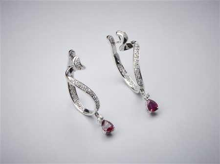  . - Orecchini pendenti in oro bianco 750/1000 a semicerchio con coppia di rubini per tot. 2,70 ct circa taglio a goccia con pavè di diamanti bianchi interni ed esterni per un totale di 1,50 ct circa.