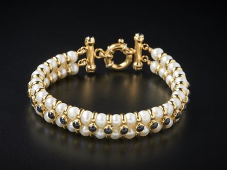  . - Bracciale di perle coltivate bianche 5.20 mm con struttura in oro giallo 750/1000 e piccoli zaffiri blu taglio cabochon.