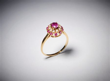  . - Anello tipo fascetta con rubino centrale ct: 0,70 contornato da diamanti taglio a brillante e rubini taglio brillante ct: 0,45 e 0,40.