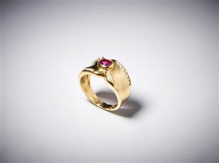  . - Anello a "fascia" in oro giallo  750/1000 con rubino centrale ovale di circa  0,35 carati con contorno di diamanti bianchi taglio a  brillante di circa 0,40 carati circa.