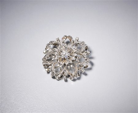  . - Spilla ramage in  oro bianco 750/1000  con diamanti taglio a brillante del peso totale di ct. 0,37 (centrale 0,19). .