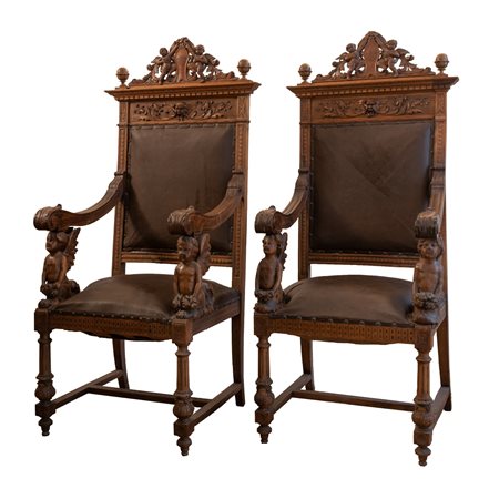  
Coppia di poltrone in noce scolpita con schienale e seduta in cuoio.  
 cm 150x56x52