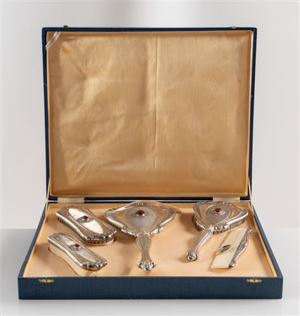 Italia, XX secolo. Set da toilette in argento 800, composto da cinque...