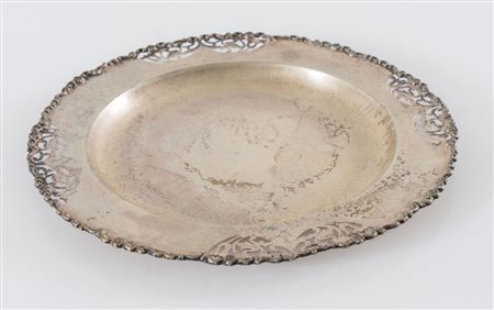 Italia, XX secolo. Piatto con bordo decorato in argento 800. Sotto la base...