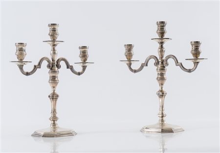 Italia, XX secolo. Coppia di candelabri in argento 800. Sotto la base reca...