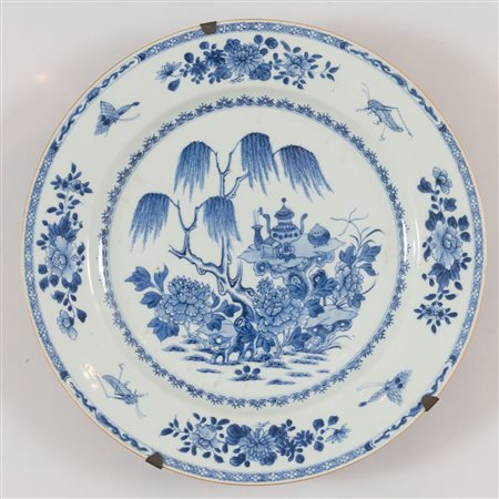 Grande vassoio in porcellana monocroma blu con pagode su promontori alberati. Cina, XVIII secolo. Diametro cm 39,7. (buono stato di conservazione)