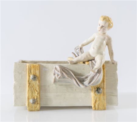 Portaoggetti in ceramica con putto. Prima metà del XX secolo. Cm 24x27x12....
