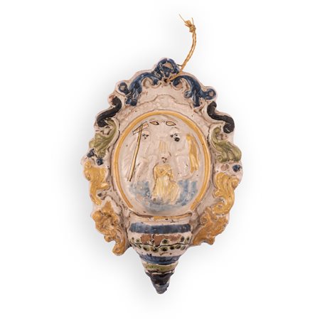 Manifattura dell'Italia settentrionale del XIX secolo ( - ) 
Acquasantiera in maiolica con decori a rilievo centrati da un medaglione raffigurante la scena del Battesimo di Cristo 
 cm 20,5x14