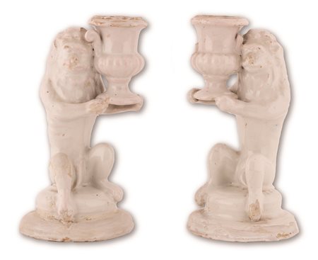 Manifattura dell'Italia meridionale del XIX secolo ( - ) 
Coppia di candelieri in maiolica bianca conformati in guisa di leone, stante a sorreggere un vaso. 
 cm 25x14x13