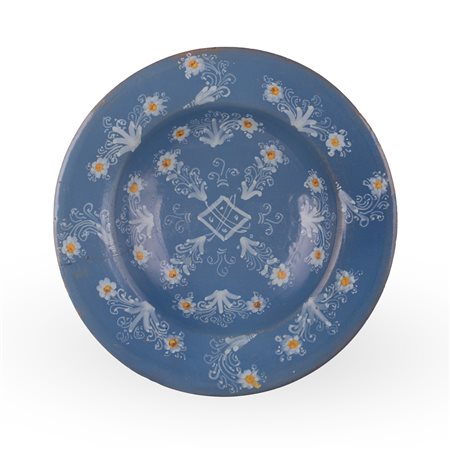 Manifattura castellana della prima metà del XVII secolo ( - ) 
Centrotavola in maiolica turchina interamente decorato con fiori e volute nei toni del bianco e del giallo 
 Ø cm 38,5