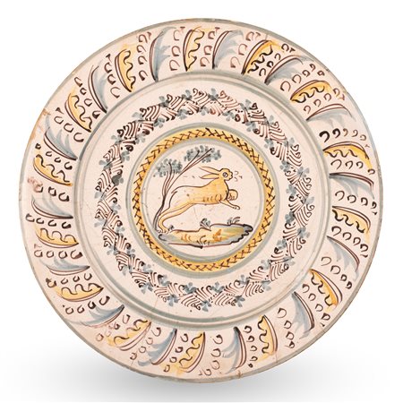 Manifattura di Bussi sul Tirino del XVII secolo ( - ) 
Maiolica a gran fuoco decorata nello stile compendiario, tesa con piume di struzzo stilizzate nei toni del blu e giallo, cavetto con decoro vegetale e lepre in fuga in un paesaggio.  
 Ø cm 41