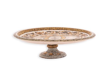 Manifattura castellana del XVIII secolo ( - ) 
Alzata in maiolica decorata in policromia con stemma araldico della famiglia Delfico con ai lati le iniziali "M.F.D." nel cavetto. Decoro floreale nei toni del blu e del giallo. 
 Ø cm 28; altezza cm 9