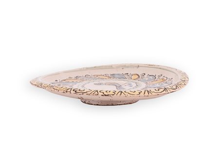 Manifattura di Bussi sul Tirino del XVII secolo ( - ) 
Alzata in maiolica decorata in policromia nello stile compendiario con al centro un uccello.  
 Ø cm 23; altezza cm 4