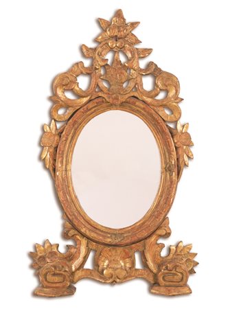 Manifattura dell'Italia centrale del XVIII secolo ( - ) 
Specchiera da appoggio intagliata e dorata a mecca a volute vegetali 
 luce cm 46x36; con cornice cm 115x66