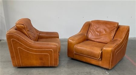 Coppia di poltrone imbottite e rivestite pelle color marrone. Italia, anni '70.