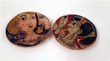 Lotto di due tondi in terracotta decorata a graffito in rilievo con volti femmi