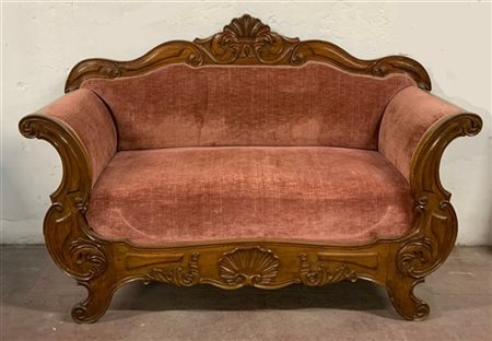 Divano di forma mossa in noce intagliato decorato a volute e valva di conchigli