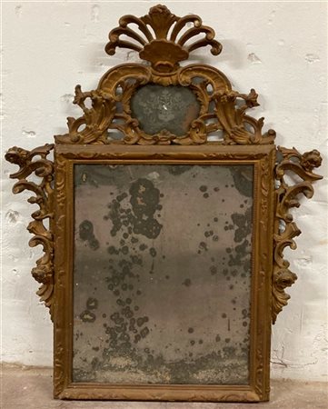 Specchiera in legno intagliato traforato e dorato a volute, fiorellini e motivi