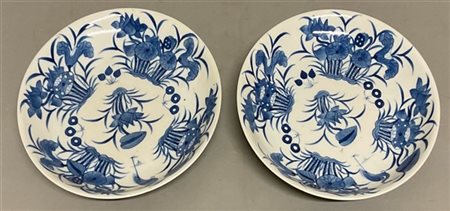 Coppia di piatti in porcellana bianca e blu decorati con aironi e fiori di loto