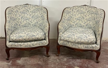 Coppia di poltroncine a pozzetto con struttura in legno intagliato e gambe moss