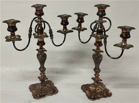 Coppia di candelabri a tre fiamme in metallo argentato con decori a foglie e fi