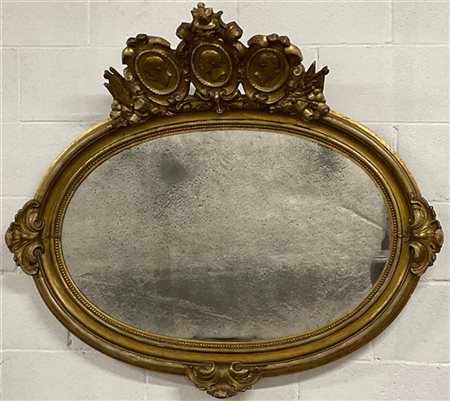 Specchiera patriottica di forma ovale in legno intagliato e dorato con fregi a