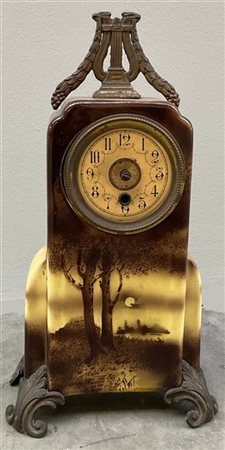 Pendola in porcellana e metallo dorato decorata a paesaggio. Quadrante a cifre